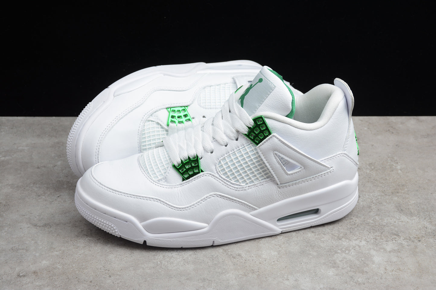 White sneakers with green accents on a gray surface