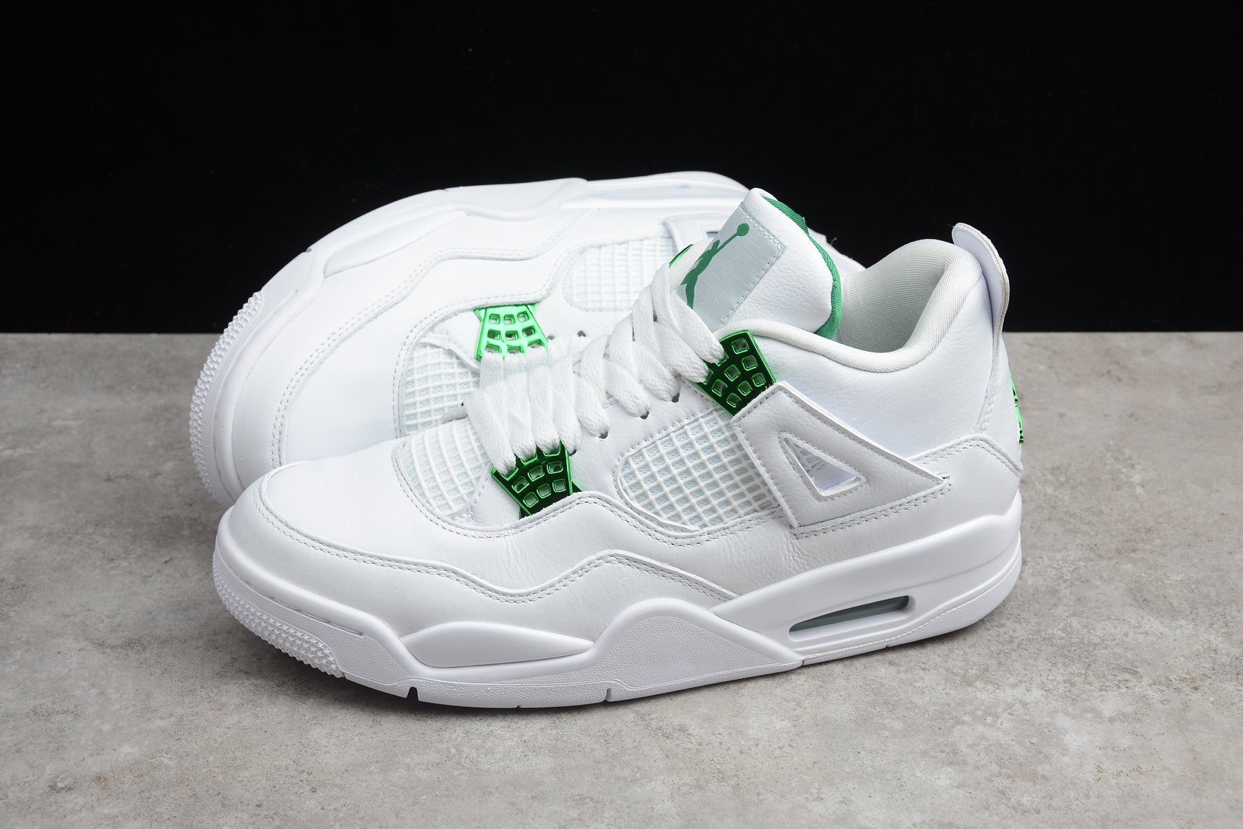 White sneakers with green accents on a gray surface